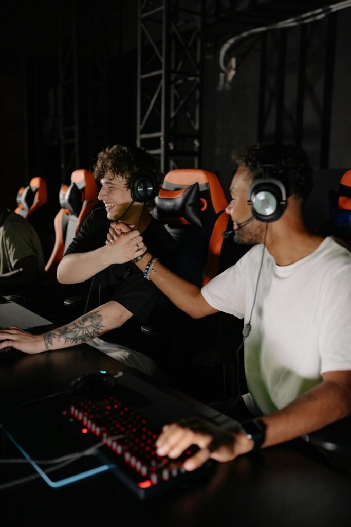 Due videogiocatori indossanti cuffie da gaming si scambiano un gesto di vittoria in una competizione di esports