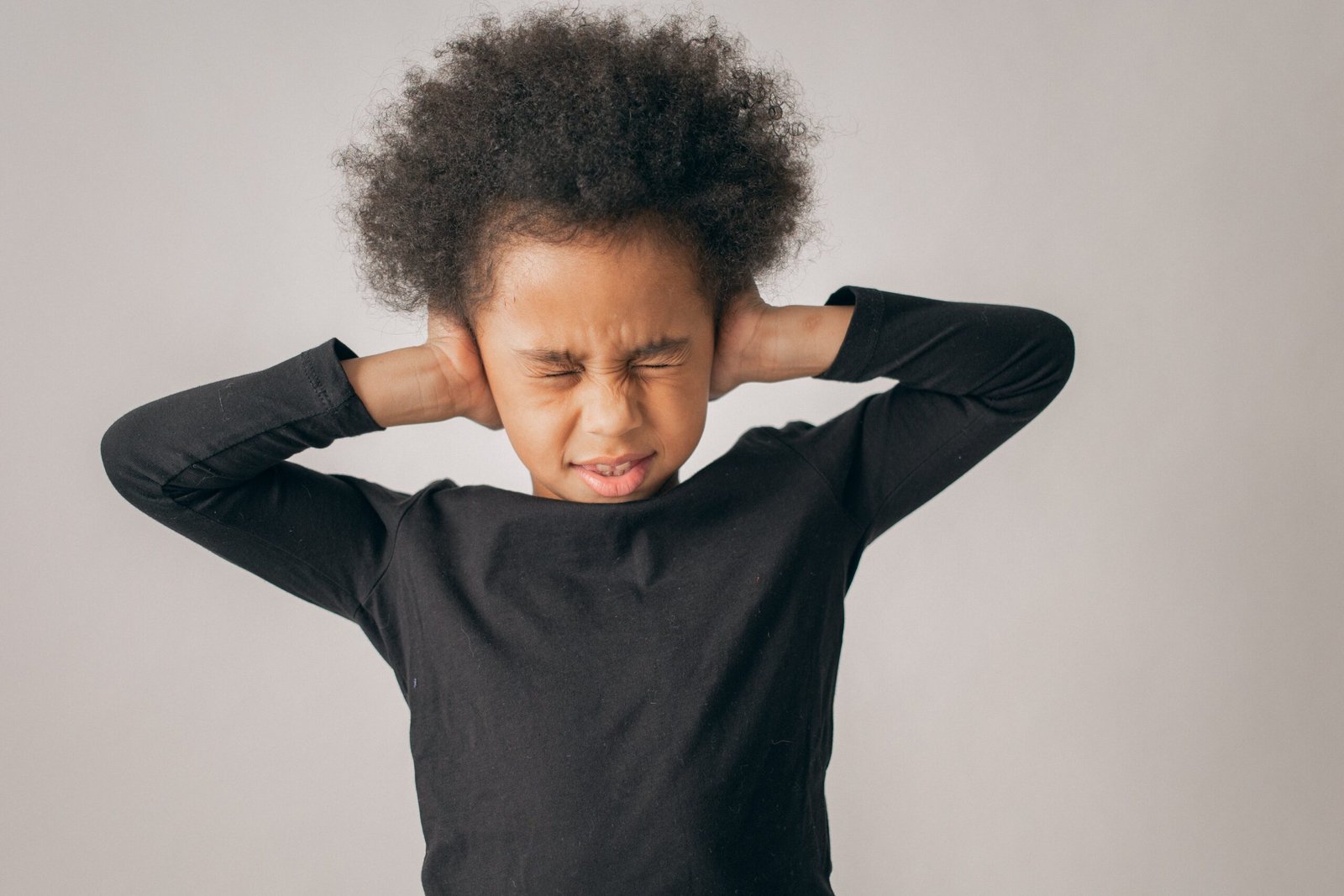 Bambino che si copre le orecchie per il fastidio